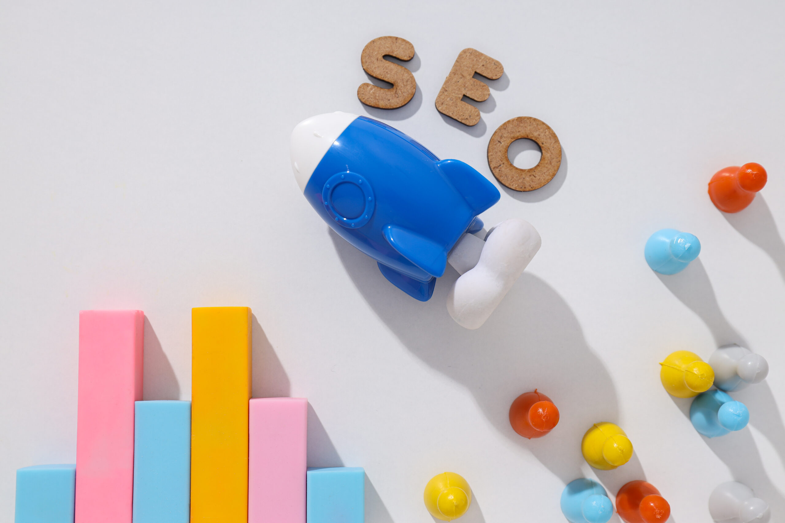 Diagram, letters and toy rocket on light background, top view